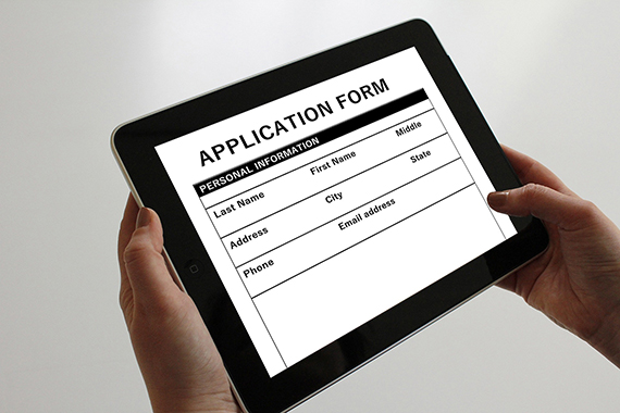 hands holding a tablet showing an online application